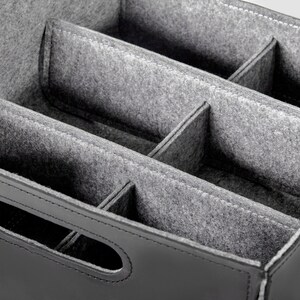 May include: Black leather storage box with a gray felt interior divided into multiple compartments.
