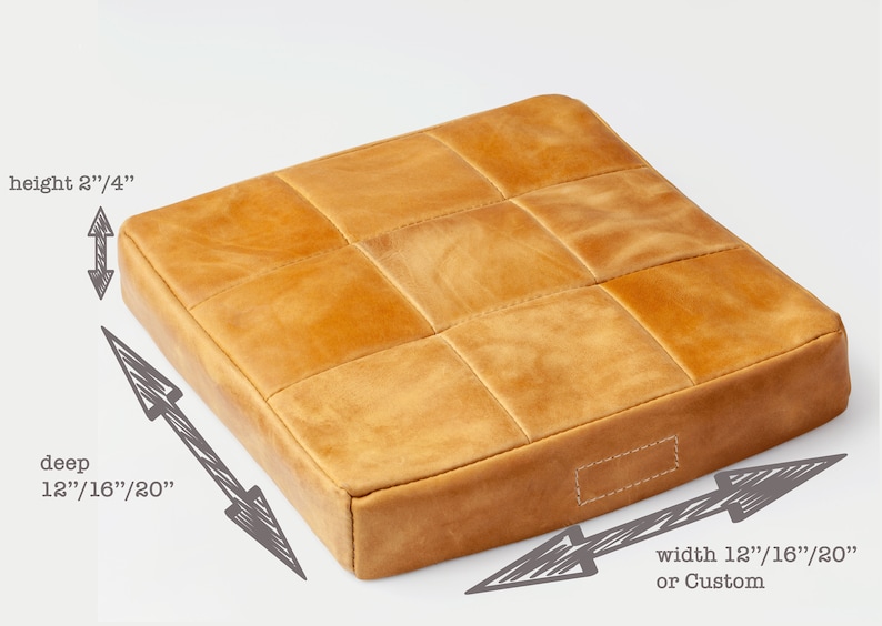 May include: A square, tan leather cushion with a grid pattern. The cushion is 2 1/4 inches high, with a depth and width of 12, 16, or 20 inches, or custom. The cushion has a stitched border.