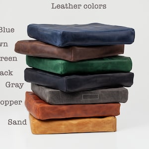 May include: A stack of eight leather cushions in different colors, including blue, brown, green, black, gray, copper, and sand.