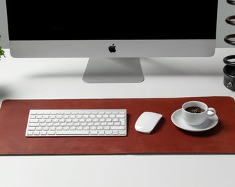 May include: A brown leather desk mat with a white keyboard, a white mouse, and a white cup of coffee on a white saucer.