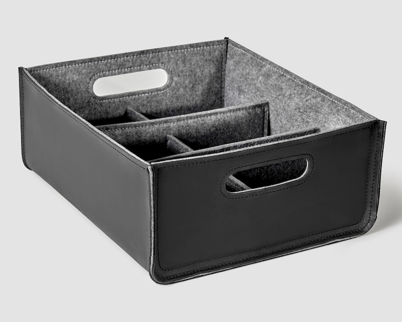 May include: Black felt storage box with a divided interior and two carrying handles. The box is made of a durable material and has a sleek, modern design.