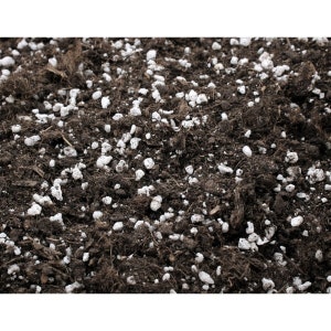 Pode incluir: Close-up de uma mistura de terra marrom escura com pequenas pedras brancas. A terra é usada para plantar e jardinagem.