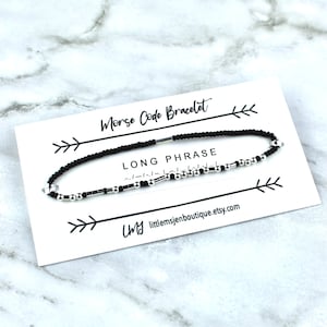 May include: Black and silver beaded bracelet with a white card that says "Morse Code Bracelet" and "LONG PHRASE". The card also includes the website "littlemsjenboutique.etsy.com".