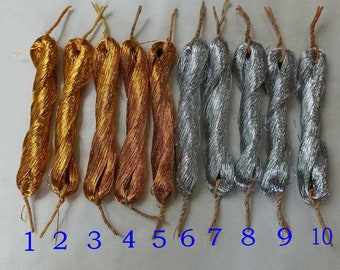 May include: A collection of ten bundles of metallic thread in various shades of gold, copper, and silver. Each bundle is numbered and has a twisted design with a natural fiber tie at the top. The number "180#" is in the top left corner.