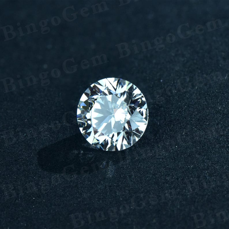Puede incluir: Una piedra preciosa redonda y transparente de diamante con muchas facetas, sobre un fondo negro.