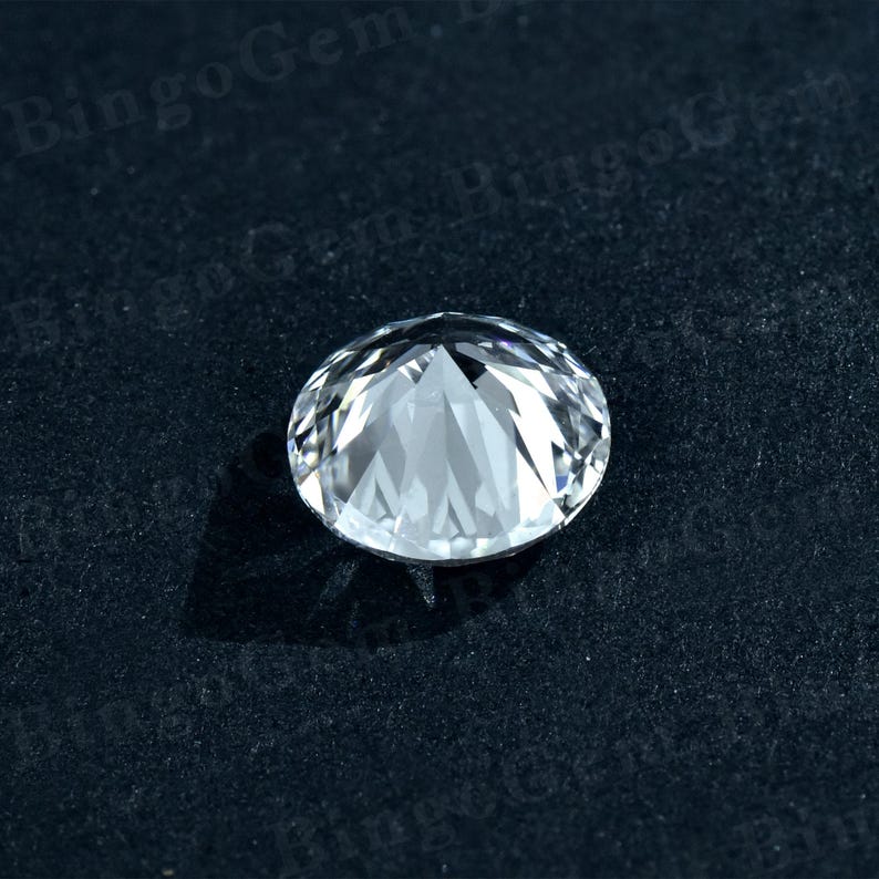 Puede incluir: Una piedra preciosa redonda transparente con muchas facetas, sobre un fondo negro.