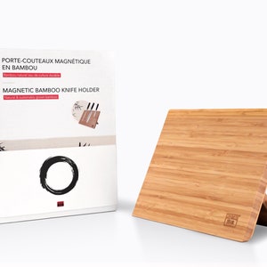 Op de afbeelding: Een bruine bamboe magnetische messenhouder met een standaard. De houder heeft een magnetische strip om messen vast te houden en de tekst "MAGNETIC BAMBOO KNIFE HOLDER" staat op de doos.