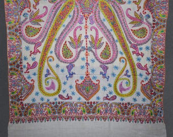 May include: A white shawl with a colourful paisley pattern. The shawl has a white border with a smaller paisley pattern.
