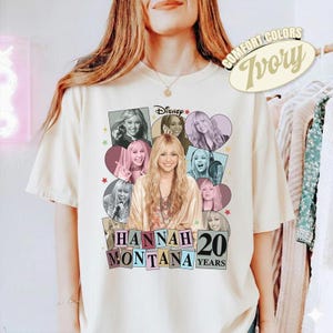 Könnte beinhalten: Elfenbeinfarbenes T-Shirt mit einer Grafik von Hannah Montana mit dem Disney-Logo. Das Design enthält Bilder von Hannah Montana in verschiedenen Posen mit dem Text "HANNAH MONTANA 20 YEARS". Das Shirt hat ein Comfort Colors-Label.