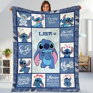 May include: A blue and white quilt with a patchwork design featuring Stitch from Lilo & Stitch. The quilt has a variety of images of Stitch, including a large image of Stitch in the center. The quilt also includes the text "Ohana means family. Family means nobody gets left behind or forgotten." and "Lisa".