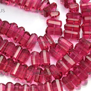 May include: Strands of faceted, rectangular beads in a vibrant magenta hue. The beads have a transparent quality, with visible internal facets. The beads are strung together, suggesting their use in jewelry making or crafting.
