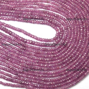 May include: Strands of small, faceted, purplish-pink gemstone beads. The beads are strung together, creating a cascading effect. The image is well-lit, showcasing the beads' color and texture. The beads are likely used for jewelry making.