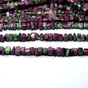 Puede incluir: Hebras de cuentas de piedras preciosas de rub&iacute; y zoisita en bruto. Las cuentas son una mezcla de colores rojo intenso y verde, cortadas en formas rectangulares irregulares. El texto "JaipurGemUS" es visible en la imagen.
