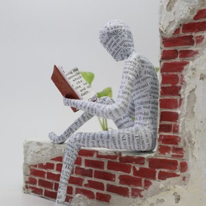 Scultura di libro, scultura in cartapesta Figurina di lettura di libri, casa unica e arredamento per scaffali Scultura in cartapesta, su vecchio muro di mattoni
