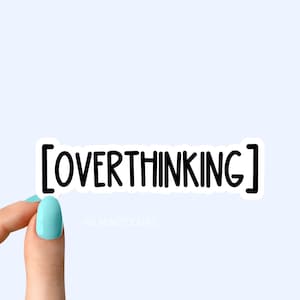 Op de afbeelding: Een witte sticker met zwarte tekst die "[OVERTHINKING]" zegt op een lichtblauwe achtergrond. Een hand houdt de sticker vast.