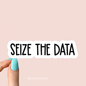May include: White sticker with black text that reads "Seize the Data". A hand is holding the sticker.