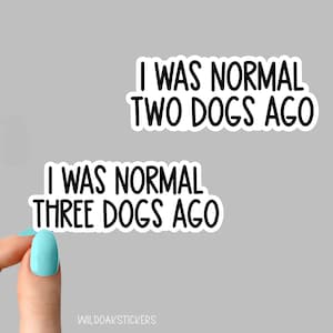 May include: Two white stickers with black text. The top sticker says "I was normal two dogs ago". The bottom sticker says "I was normal three dogs ago".