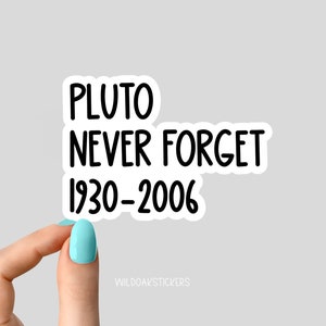 May include: A white sticker with black text that reads "Pluto Never Forget 1930-2006".