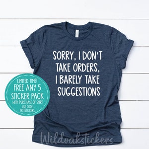 May include: A navy blue t-shirt with white text that reads "Sorry, I don't take orders, I barely take suggestions". A teal circle sticker with white text is in the lower left corner of the image. The sticker says "Limited Time! Free Any 5 Sticker Pack with purchase of shirt. Use code FREESTICKERS."