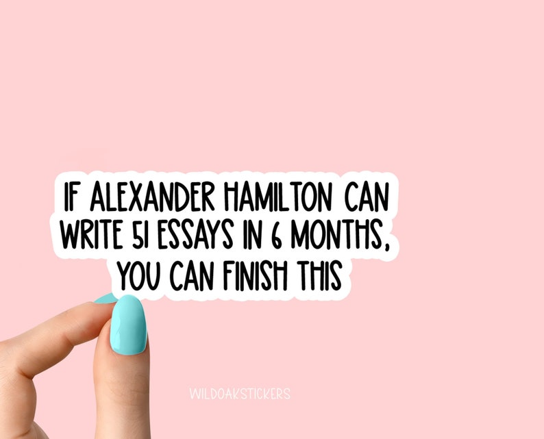 K&ouml;nnte beinhalten: Ein wei&szlig;er Aufkleber mit schwarzem Text, der lautet: "Wenn Alexander Hamilton 51 Essays in 6 Monaten schreiben kann, kannst du das auch schaffen." Der Aufkleber wird von einem Finger mit hellblauem Nagellack gehalten.