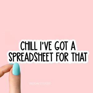 May include: White sticker with black text that reads "Chill I've got a spreadsheet for that". A hand is holding the sticker against a light pink background.