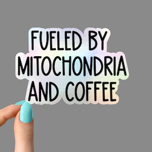 May include: A holographic sticker with the text "Fueled by Mitochondria and Coffee" in black lettering.