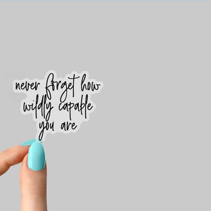May include: A white sticker with black text that reads "never forget how wildly capable you are".