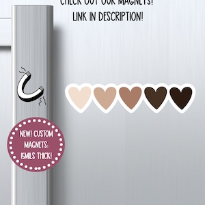 K&ouml;nnte beinhalten: F&uuml;nf herzf&ouml;rmige Magnete in verschiedenen Braunt&ouml;nen, von hell bis dunkel. Die Magnete sind 15 mil dick und in individuellen Designs erh&auml;ltlich. Der Text "NEW! CUSTOM MAGNETS: 15MILS THICK!" befindet sich auf einem rosa Kreis mit wei&szlig;en Punkten. Der Text "CHECK OUT OUR MAGNETS! LINK IN DESCRIPTION!" befindet sich oben im Bild. Der Text "WILDOAKSTICKERS" befindet sich unten im Bild.