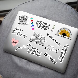 Pode incluir: Um laptop branco com v&aacute;rios adesivos, incluindo um girassol com o texto "Keep Growing and Read On", um livro com o texto "You Had Me At Rocks", um cora&ccedil;&atilde;o com o texto "Field Hockey", e uma onda com o texto "Stronger Than Yesterday".