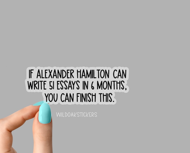 K&ouml;nnte beinhalten: Ein wei&szlig;er Aufkleber mit schwarzem Text, der lautet: "Wenn Alexander Hamilton 51 Essays in 6 Monaten schreiben kann, kannst du das auch schaffen." Der Aufkleber wird von einer Hand mit hellblauem Nagellack gehalten. Der Text "WILDOAKSTICKERS" befindet sich am unteren Rand des Aufklebers.
