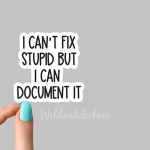 May include: White sticker with black text that reads "I can't fix stupid but I can document it". The sticker is being held by a hand with light blue nail polish.
