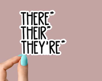 May include: A white sticker with black text that reads "THERE* THEIR* THEY'RE*"