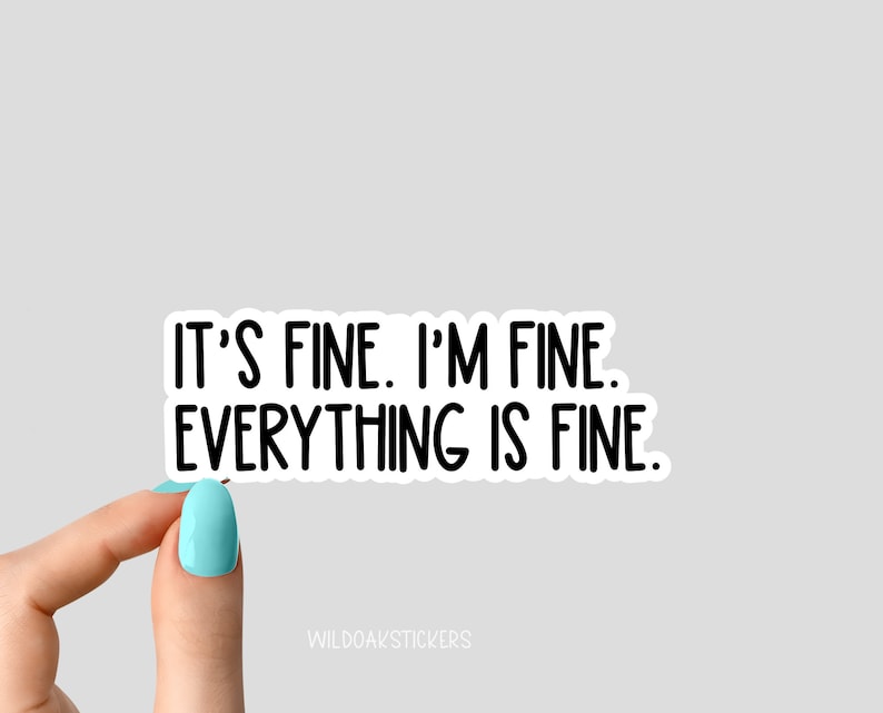 May include: White sticker with black text that reads "It's fine. I'm fine. Everything is fine." A hand is holding the sticker.