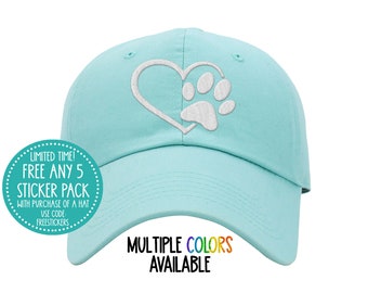 May include: A light blue baseball cap with a white embroidered paw print inside a heart. The text "MULTIPLE COLORS AVAILABLE" is printed on the brim of the cap.