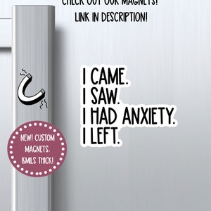 May include: A white refrigerator door with a pink and white magnet that says "I came. I saw. I had anxiety. I left." The magnet is next to a smaller pink and white magnet that says "New! Custom Magnets: 15mils thick!" and a black and white illustration of a horseshoe magnet.