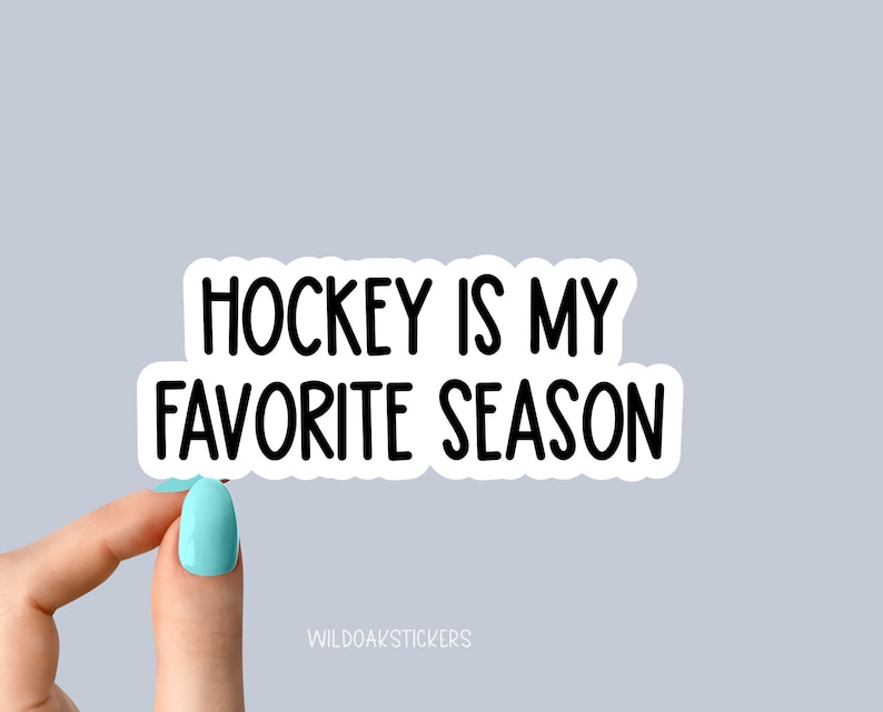 Pode incluir: Etiqueta branca com texto preto que diz "Hockey is my favorite season". Uma m&atilde;o est&aacute; segurando a etiqueta.