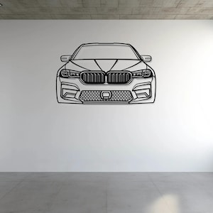 May include: Black and white line drawing of a car's front view, mounted on a white wall. The car features a detailed grille, headlights, and a prominent front bumper. The artwork is displayed in a modern, minimalist interior setting.
