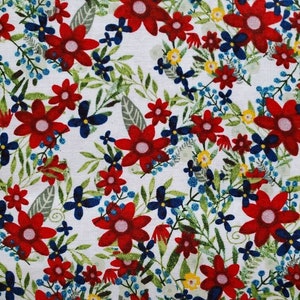 May include: A white fabric with a red, blue, and yellow floral pattern. The fabric features a variety of flower shapes and sizes, including large red flowers with white centers and smaller blue and yellow flowers.
