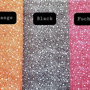 May include: Three fabric swatches with white polka dots on different colored backgrounds. The swatches are labeled "Orange", "Black", and "Fuchsia".