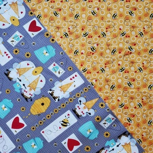 Honey Bee Gnomes by Lori Nawyn for Studio E. Patchwork Gnomes and Scattered Bees in Gray and Gold. By the Half Yard. 18" long x 43" wide.