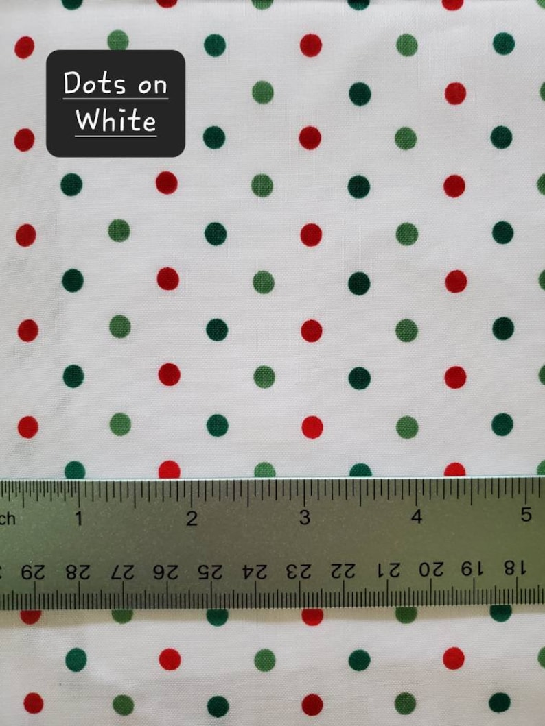 May include: White fabric with a pattern of red and green polka dots. The text "Dots on White" is in a black box in the upper left corner. A ruler is at the bottom of the image.