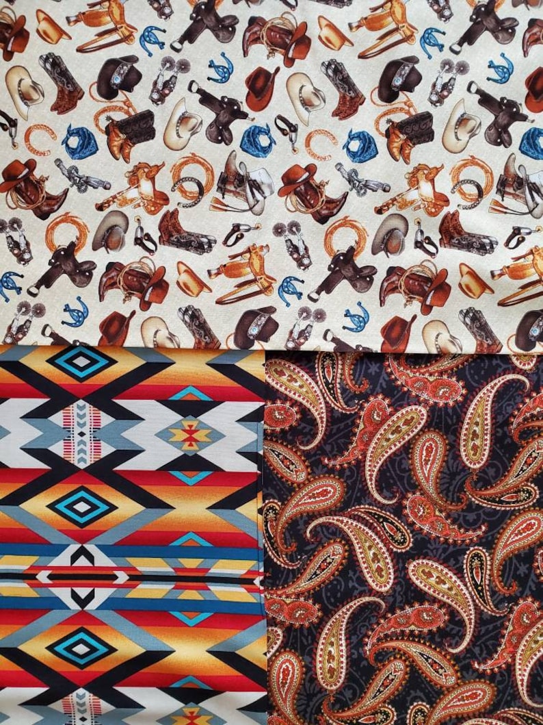May include: A fabric with two different patterns. The top pattern is a white background with brown, black, and blue cowboy-themed images. The bottom pattern is a black background with orange and gold paisley designs.