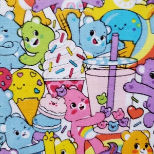 May include: A colorful fabric with a repeating pattern of cartoon bears, ice cream cones, and other sweet treats. The bears are all different colors and have different expressions. The background is white with a rainbow pattern.
