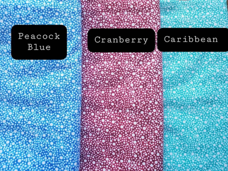 May include: Three fabric swatches with a white polka dot pattern on a blue, burgundy, and turquoise background. The swatches are labeled "Peacock Blue", "Cranberry", and "Caribbean".