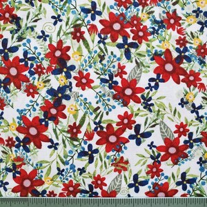May include: White fabric with a red, blue, and yellow floral pattern. The fabric is shown with a ruler for scale.