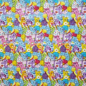 May include: A colorful fabric with a repeating pattern of cartoon bears, ice cream cones, and drinks. The bears are in various colors, including blue, purple, yellow, and pink. The background is white with small white dots.
