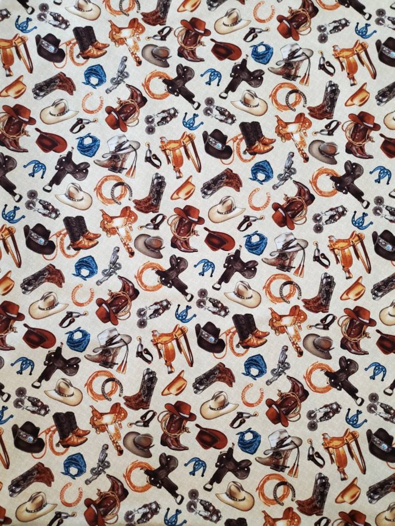 May include: A beige fabric with a repeating pattern of cowboy boots, saddles, hats, and other western-themed imagery. The pattern is in shades of brown, blue, and white.