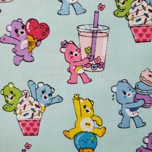 May include: A light blue background with a repeating pattern of colorful cartoon bears enjoying various sweet treats. The bears are holding ice cream cones, cupcakes, and bubble tea.