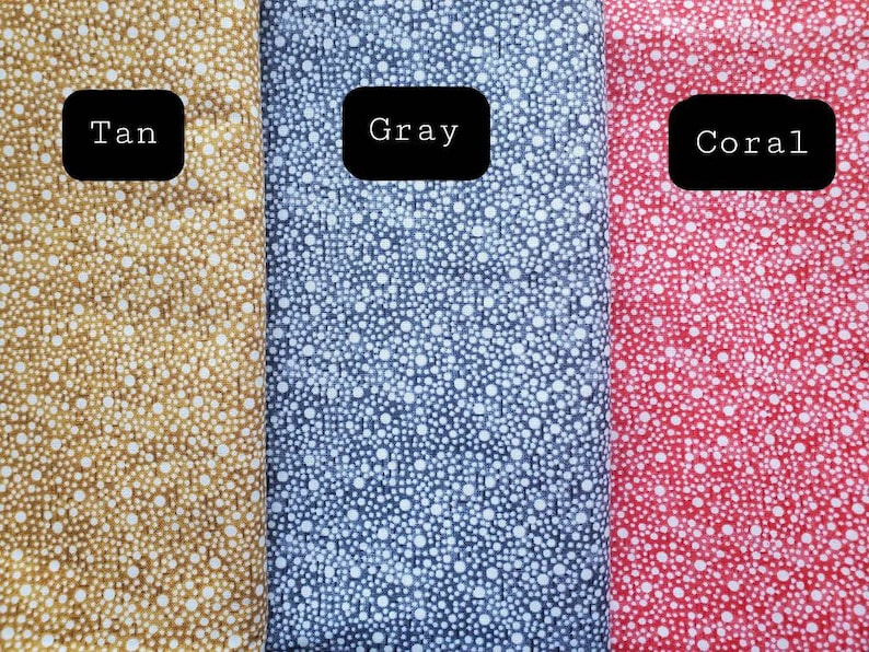 May include: Three fabric swatches with white polka dots on a tan, gray, and coral background. The swatches are labeled "Tan", "Gray", and "Coral".