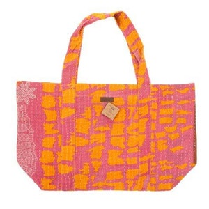 May include: A pink and orange tote bag with a geometric pattern. The bag has two long straps and a small tag with the word "Kantha" on it.